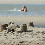 A simple sand castle with water in the background
