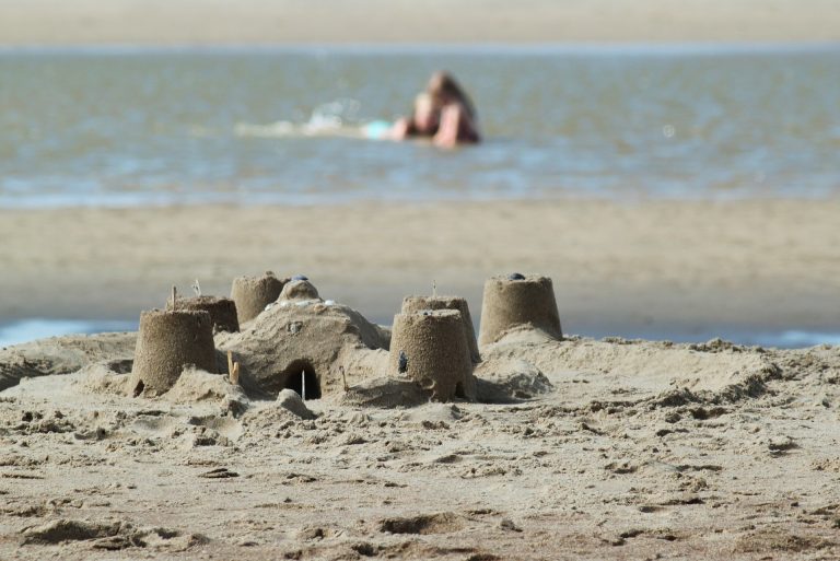 A simple sand castle with water in the background